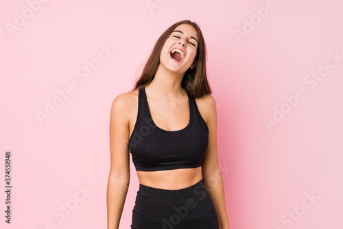 Young caucasian fitness woman doing sport isolated relaxed and happy laughing  neck stretched showing teeth.