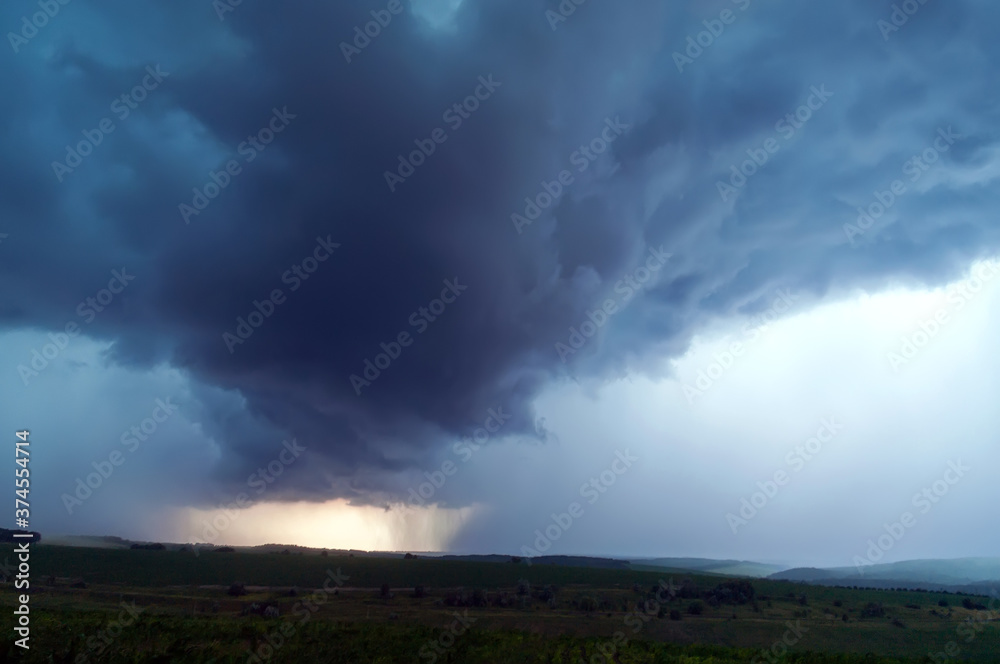 Thunderclouds and downpour over the hills. The sky with storm clouds. Thunderclouds and downpour over the hills. The sky with storm clouds.