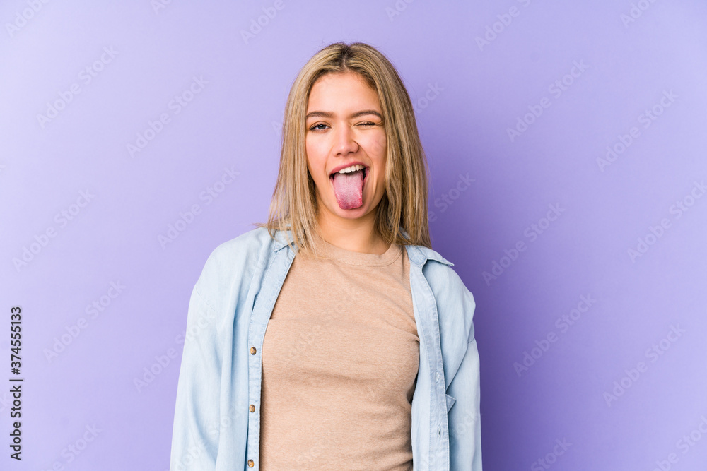 Young blonde caucasian woman isolated funny and friendly sticking out tongue. Young blonde caucasian woman isolated funny and friendly sticking out tongue.