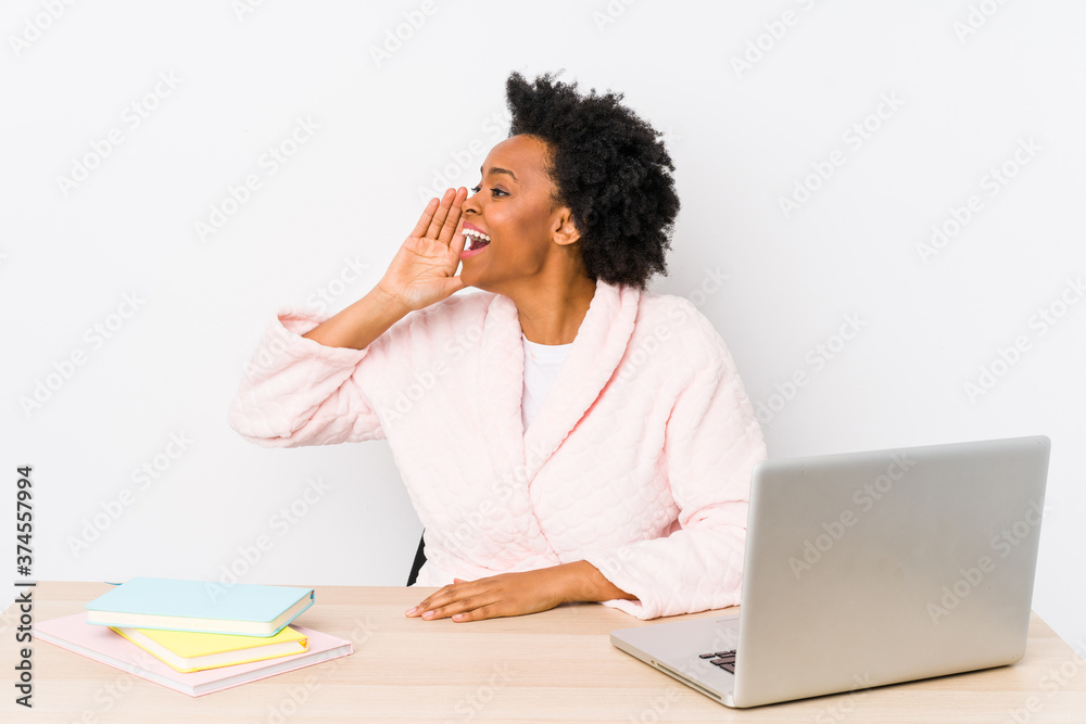 Middle aged african american woman working at home isolated shouting and holding palm near opened mouth. Middle aged african american woman working at home isolated shouting and holding palm near opened mouth.