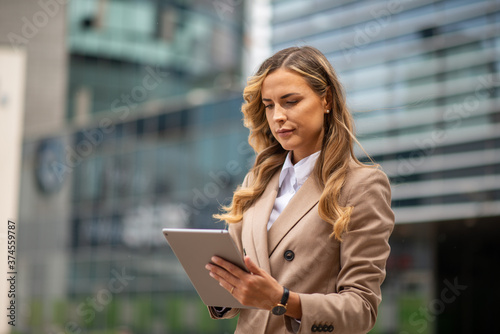 Blonde businesswoman using a digital tablet outdoor