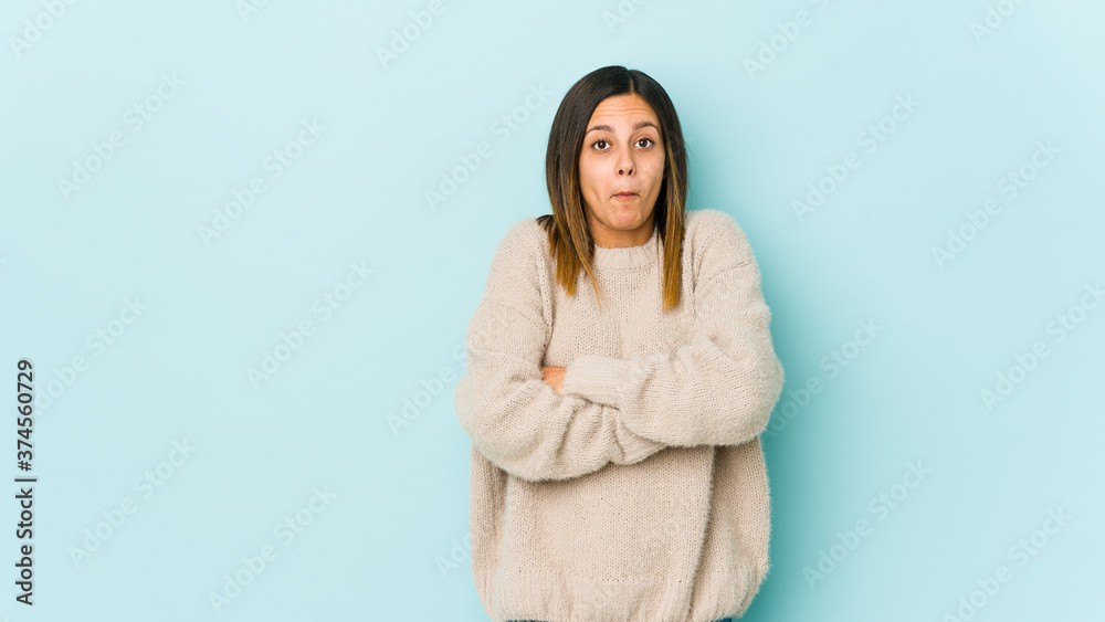 Young woman isolated on blue background shrugs shoulders and open eyes confused. Young woman isolated on blue background shrugs shoulders and open eyes confused.