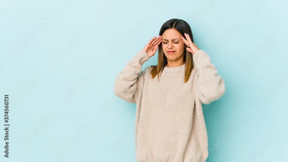 Young woman isolated on blue background touching temples and having headache. Young woman isolated on blue background touching temples and having headache.