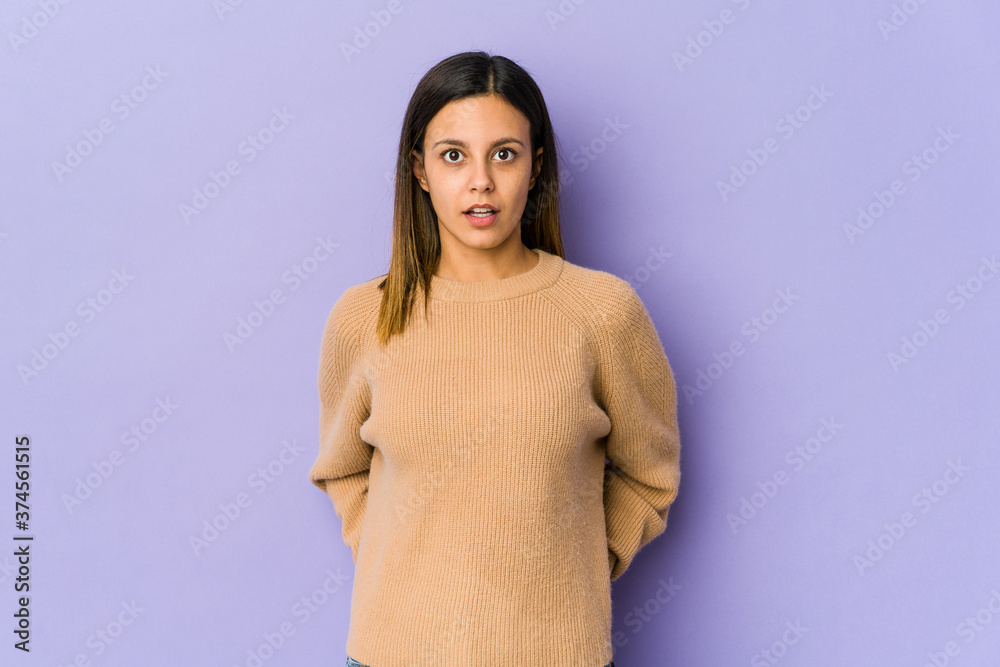 Young woman isolated on purple background being shocked because of something she has seen. Young woman isolated on purple background being shocked because of something she has seen.