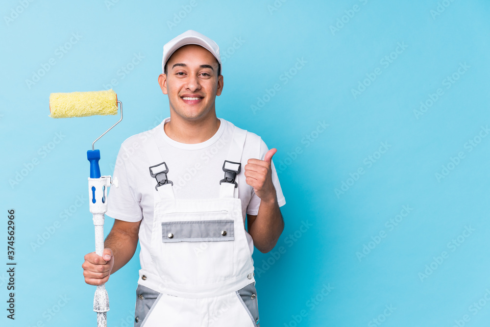 Young professional painter latin man isolated smiling and raising thumb up Young professional painter latin man isolated smiling and raising thumb up
