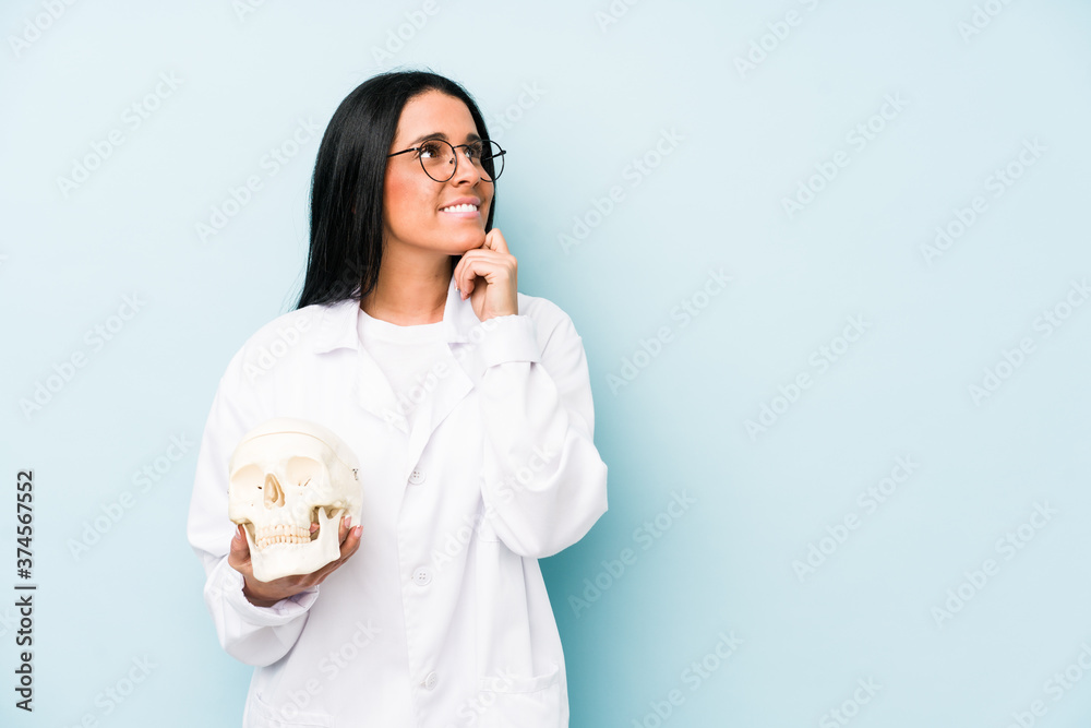 Doctor caucasian woman isolated on blue background relaxed thinking about something looking at a copy space. Doctor caucasian woman isolated on blue background relaxed thinking about something looking at a copy space.