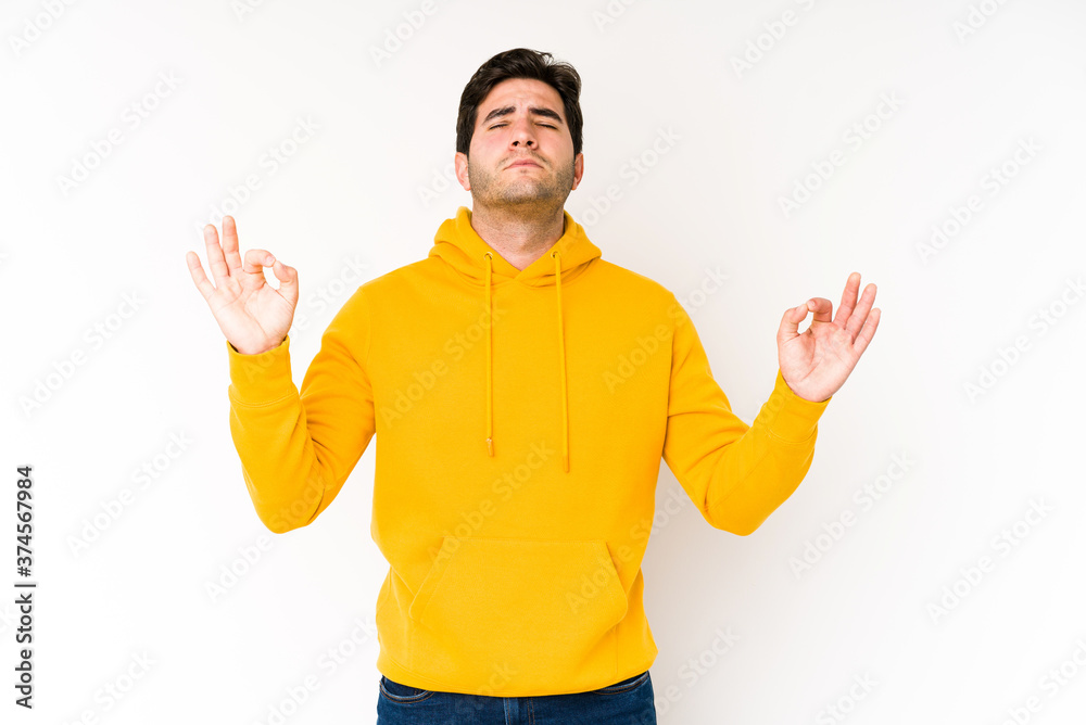 Young man isolated on white background relaxes after hard working day, she is performing yoga. Young man isolated on white background relaxes after hard working day, she is performing yoga.