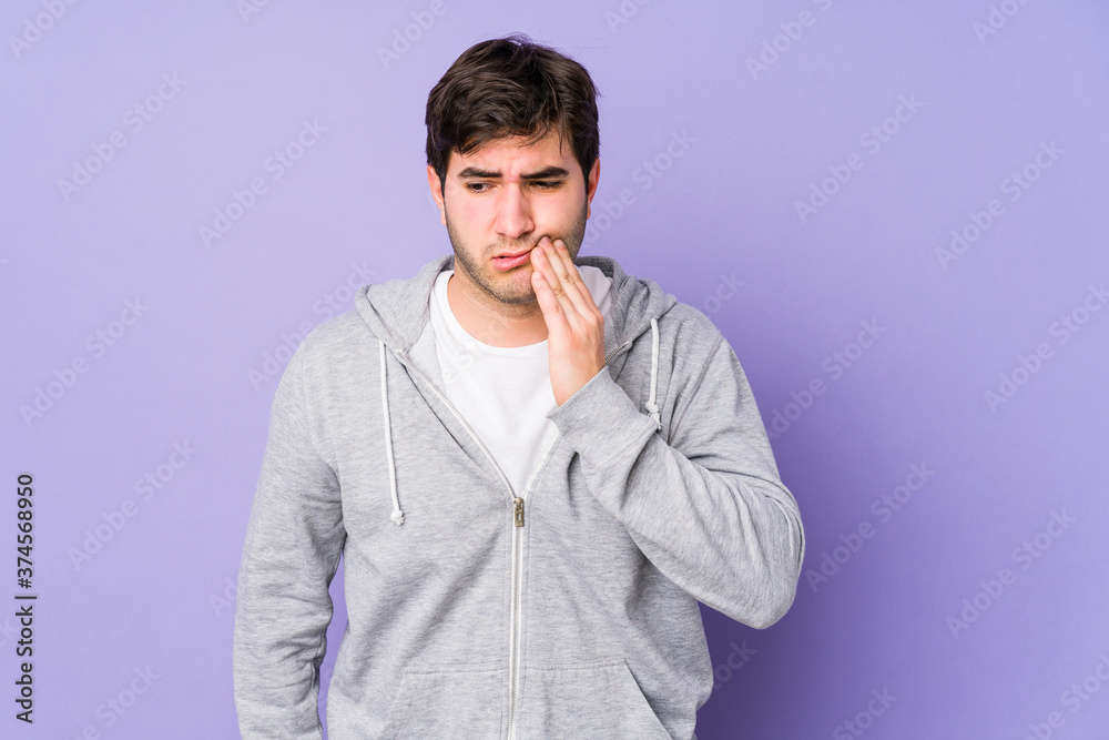 Young man isolated on purple background having a strong teeth pain, molar ache. Young man isolated on purple background having a strong teeth pain, molar ache.