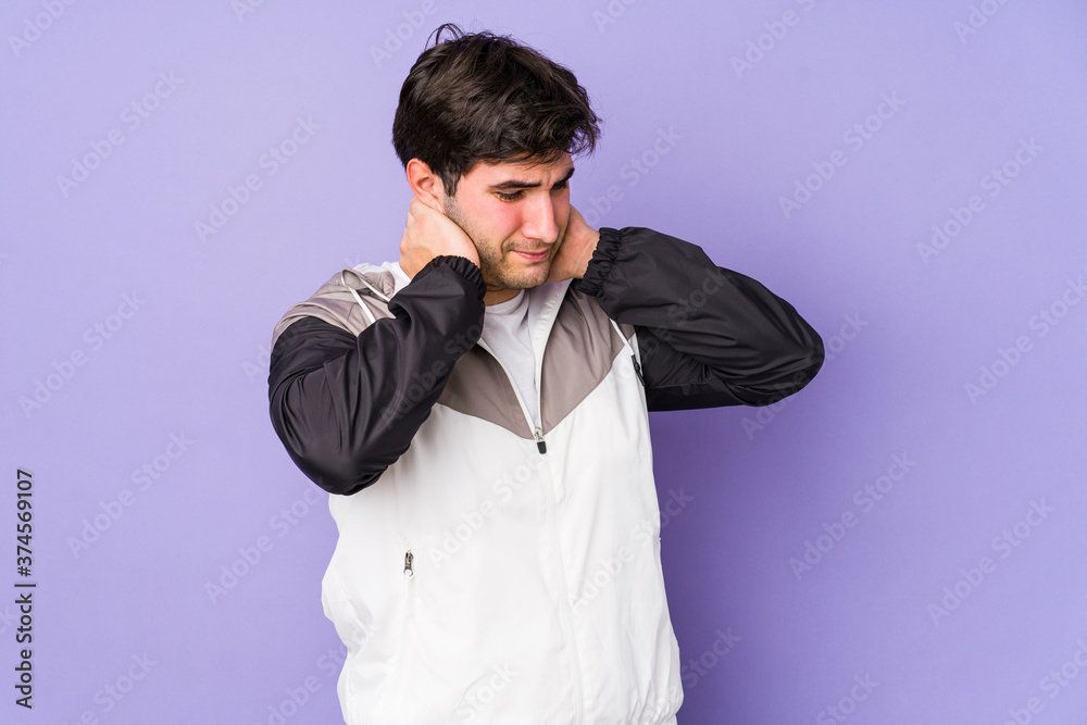 Young man isolated on purple background suffering neck pain due to sedentary lifestyle.