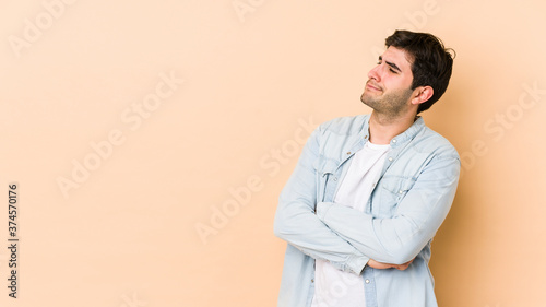 Young man isolated on beige background dreaming of achieving goals and purposes