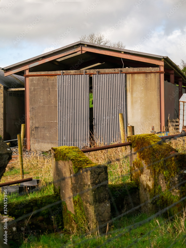 Small old rusty shed building on a farm with sliding doors. Nobody.