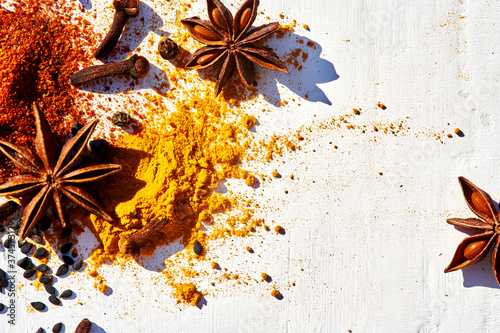 Fototapeta Naklejka Na Ścianę i Meble -  Close-up Frame of various spices chili, turmeric, star anise, cloves and sesame seeds on a white background.