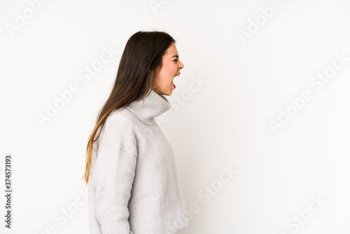Young caucasian woman isolated on a white background shouting towards a copy space © Asier