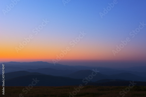 The first or last rays of the sun on a mountain pass. Morning and evening in nature. Colorful sunset and sunrise over the mountain hills. Carpathians in summer and autumn. © Mykhailo Abramov