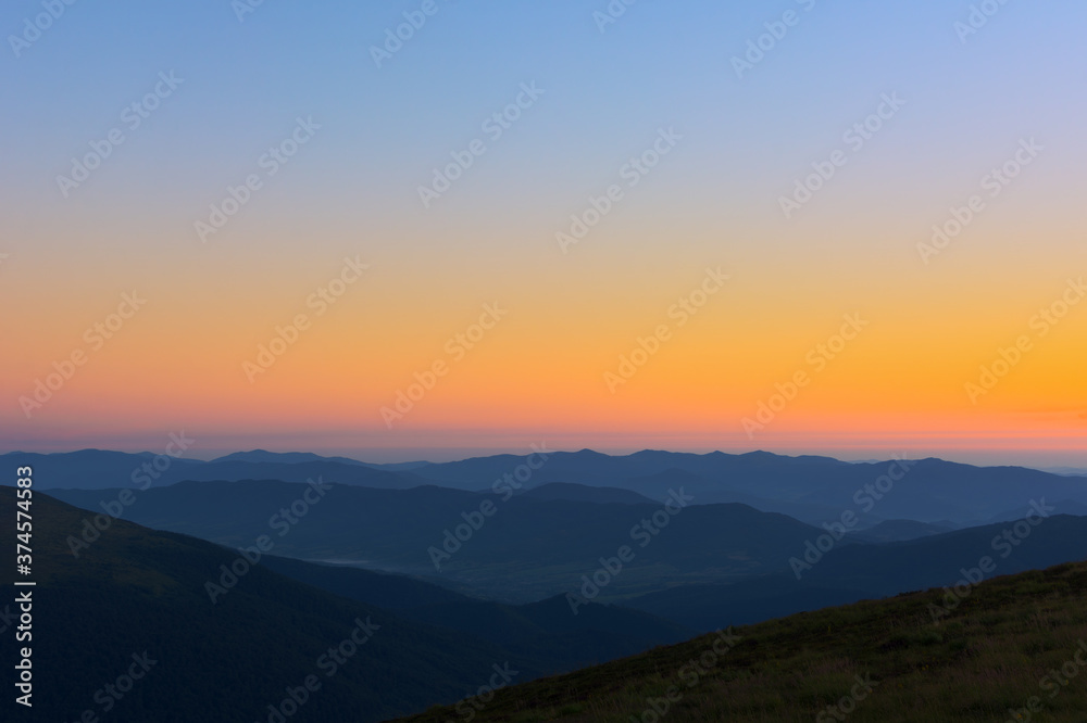 The first or last rays of the sun on a mountain pass. Morning and evening in nature. Colorful sunset and sunrise over the mountain hills. Carpathians in summer and autumn.