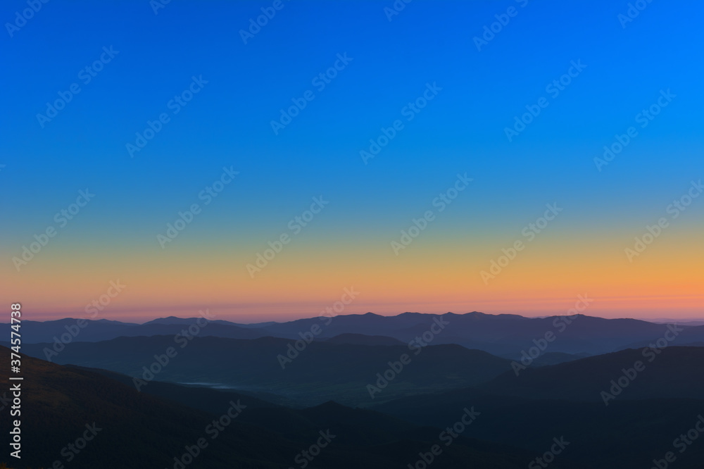 The first or last rays of the sun on a mountain pass. Morning and evening in nature. Colorful sunset and sunrise over the mountain hills. Carpathians in summer and autumn.