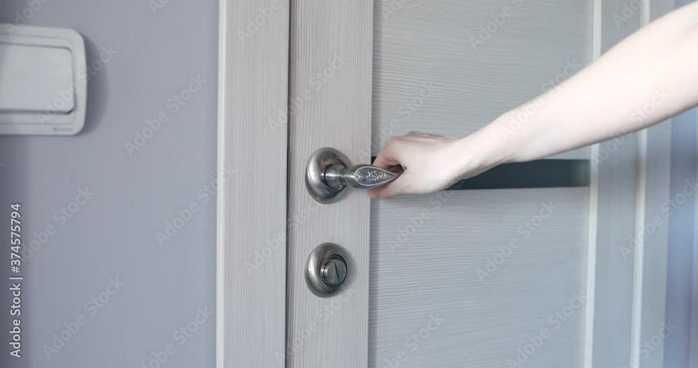 a woman's hand holds the door handle, opens and closes