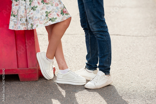 legs close-up of  girl and  guy, concept story, white sneakers on feet