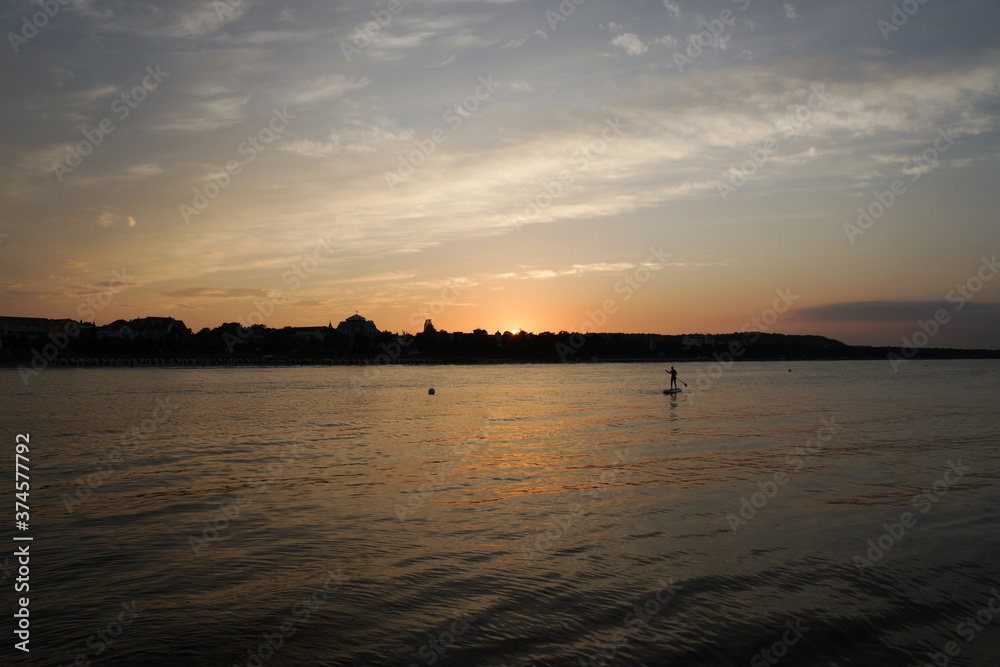 Frau auf Stand-Up-Paddelboard im Sonnenuntergang