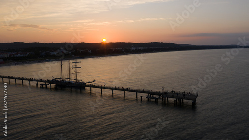 Segelschiff an Seebrücke im Sonnenuntergang