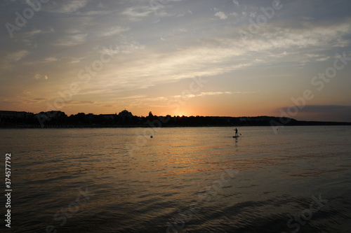 Frau auf Stand-Up-Paddelboard im Sonnenuntergang