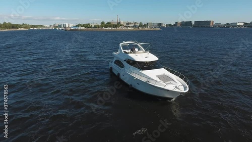 The man drive the yacht from the upper deck. View from a quadcopter