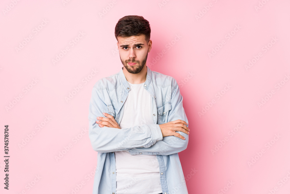 Young caucasian business man posing in a white background isolated frowning face in displeasure, keeps arms folded.< mixto > Young caucasian business man posing in a white background isolated frowning face in displeasure, keeps arms folded.< mixto >