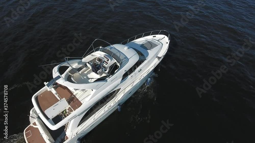 The man drive the yacht from the upper deck. View from a quadcopter