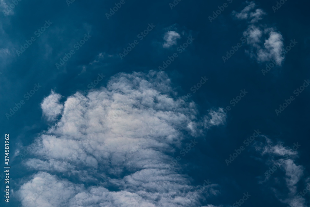 Fototapeta premium thin cirrocumulus clouds, floating under a blue sky covered by a very fine mist.