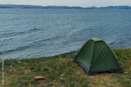 Lakeside tent  baikal in summer  green tent  tourism and travel. Beautiful sky background
