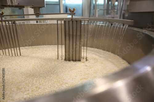 Adding water to curd and whey in tank at cheese factory