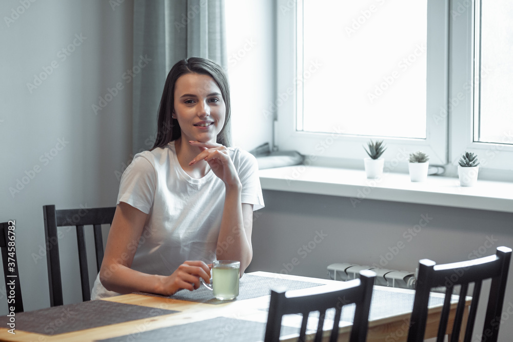 beautiful young woman drinking hot beverage
