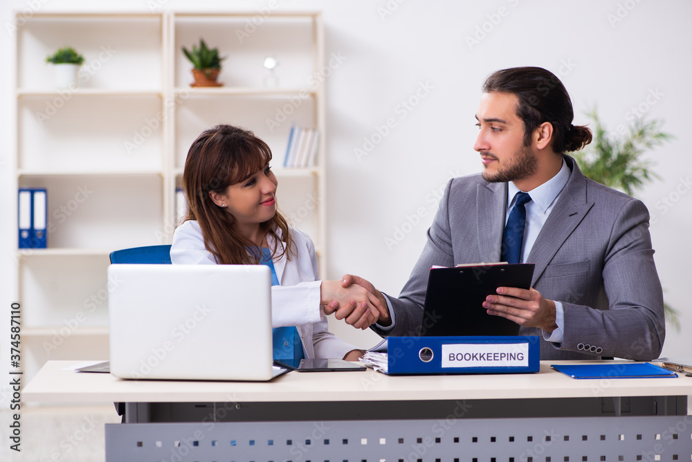 Obraz premium Young female doctor and sick businessman in the office