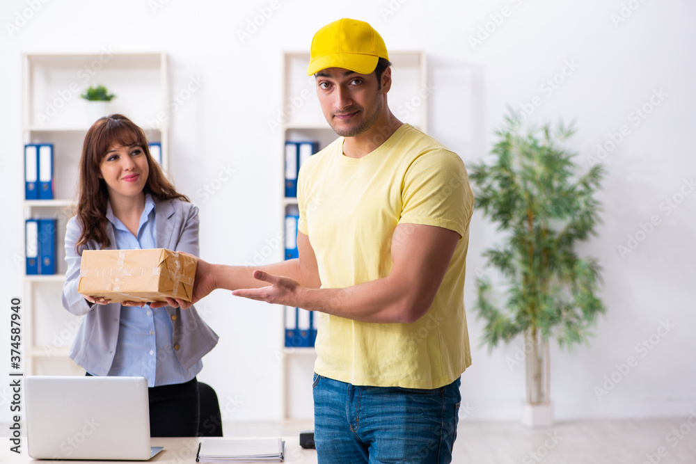 Young male courier delivering parcel to the office Young male courier delivering parcel to the office