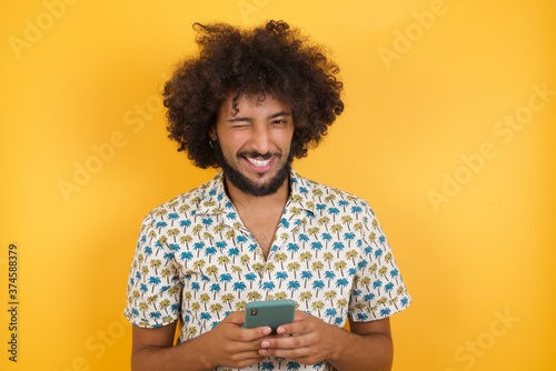 Portrait of handsome caucasian businessman isolated over yellow background,taking a selfie celebrating success