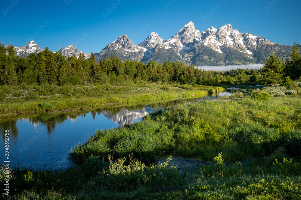  Schwabachers Landing in the early morning in Grand Teton National Park, with mountain reflections on the water creek