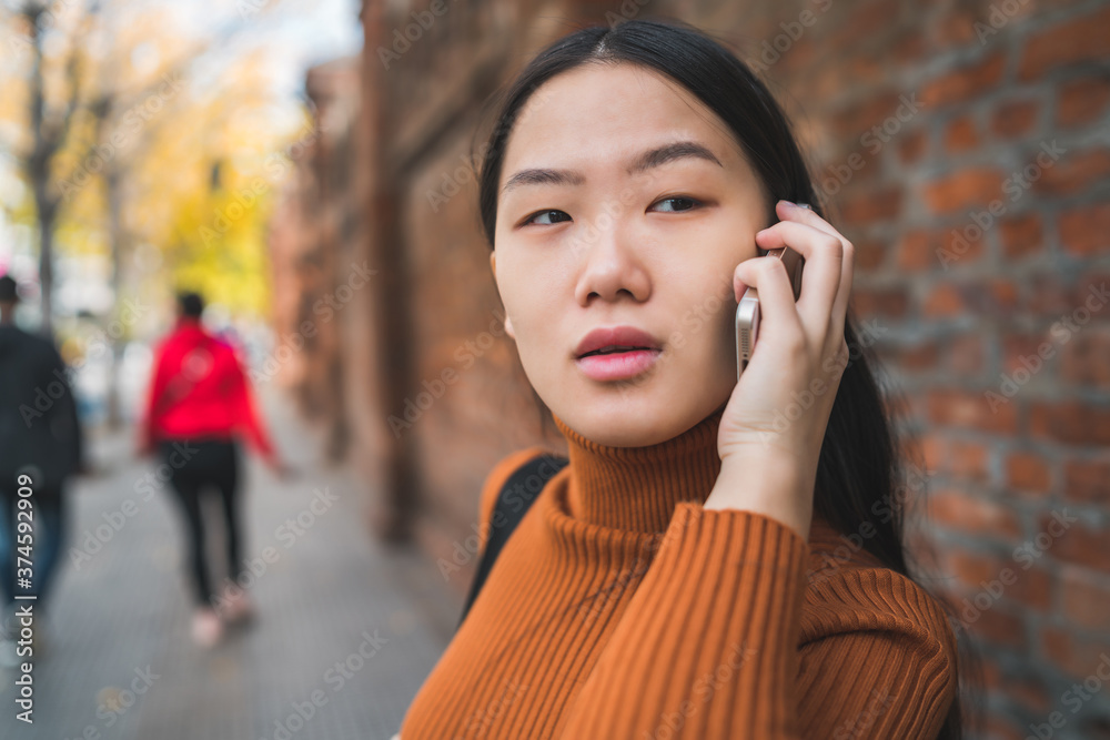 Asian woman talking on the phone. Asian woman talking on the phone.