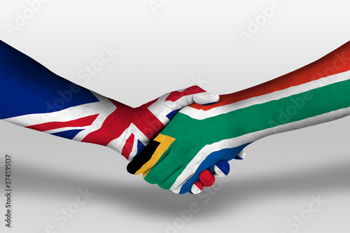 Fotografie Handshake between south africa and united kingdom flags painted on hands, illustration with clipping path