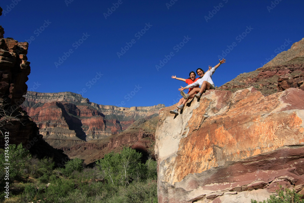 Two young women enjoy view of Grand Canyon from near Upper Tapeats Campground in Grand Canyon National Park, Arizona.