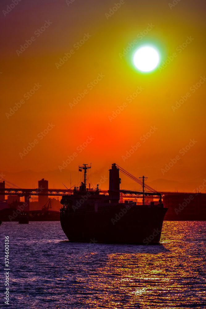 貨物船のシルエットと夕景