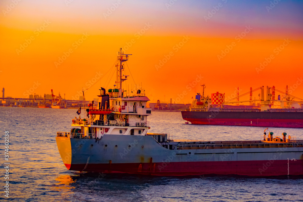 Fototapeta premium 貨物船のシルエットと夕景