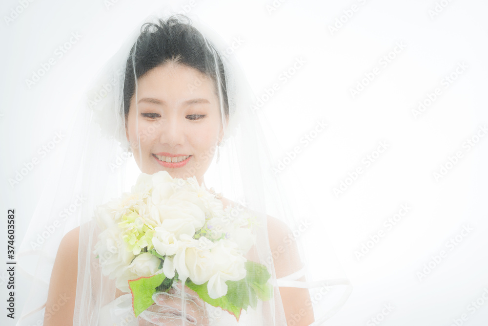 ウェディングベールを被って微笑む花嫁