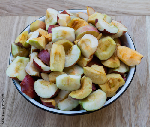 Apples in a bowl on a wooden background, In the process of cooking apple juice