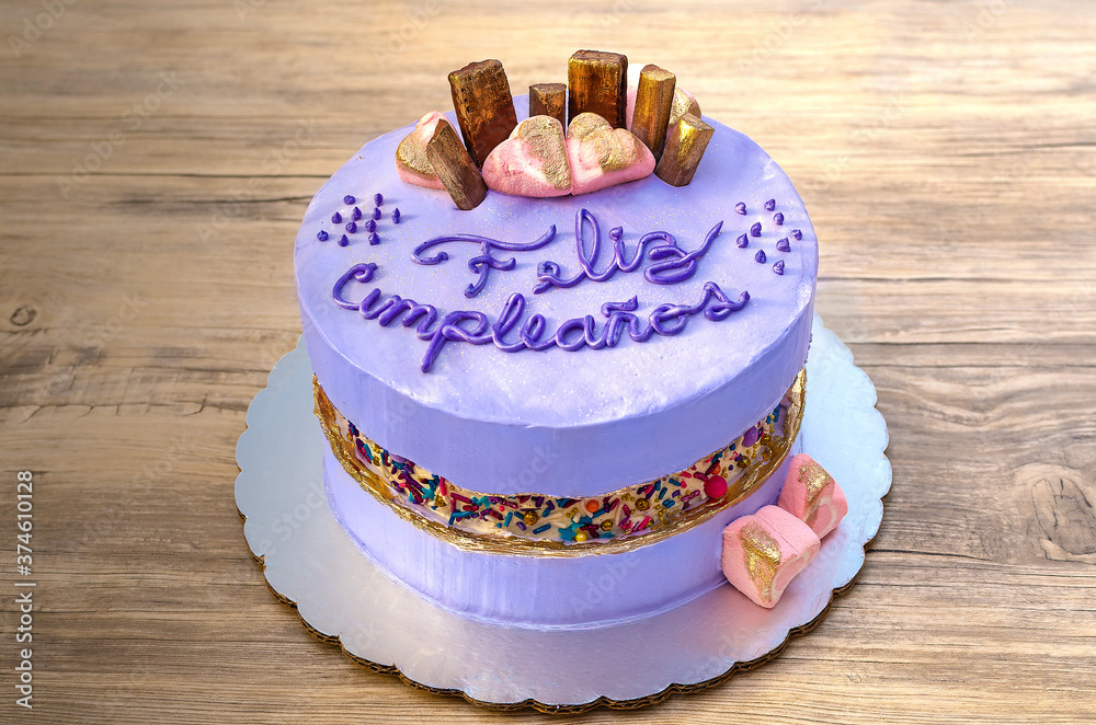 Pastel de cumpleaños color malva, morado, decorado con chocolates y chispas  coloridas sobre fondo de madera. 素材庫相片| Adobe Stock