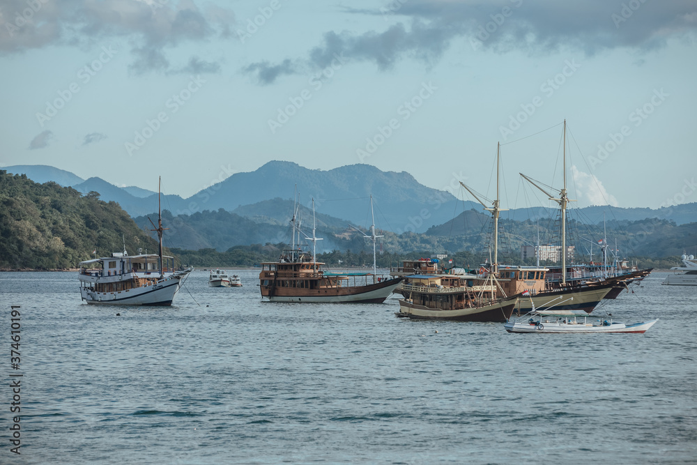 parking of ships.city port.Wild islands of Indonesia. Flores tropical paradise. Labuan Bajo. drone shooting. Wild beaches, blue logons, coral reefs, green hills. aerial view. boat trip safari. harbor 