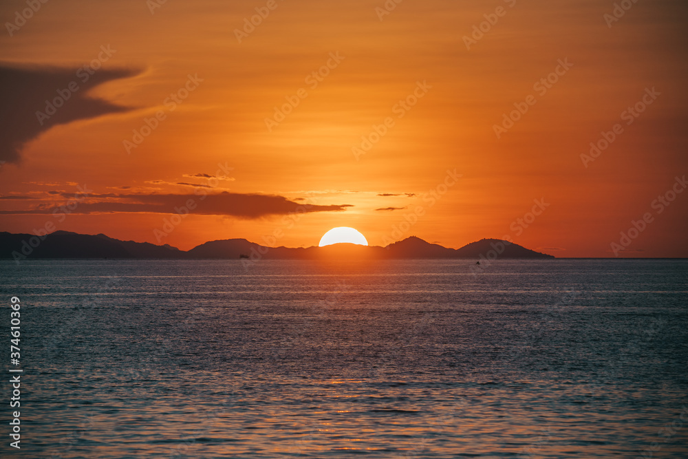 the sunset in an even circle over the horizon. warm orange color.High quality photo Flores. Indonesia