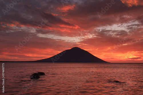 Volcano on the sea in the rays of the setting sun, sea of Okhotsk, Iturup island photo