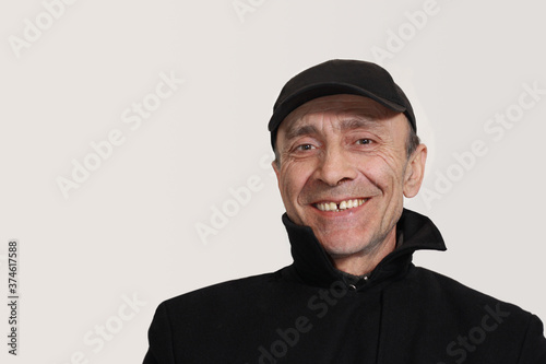 Portrait of smiling georgian man over 50 in outerwear on gray background with copy space