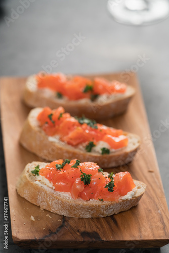 Bruschettas with salmon and cream cheese on olive wood board