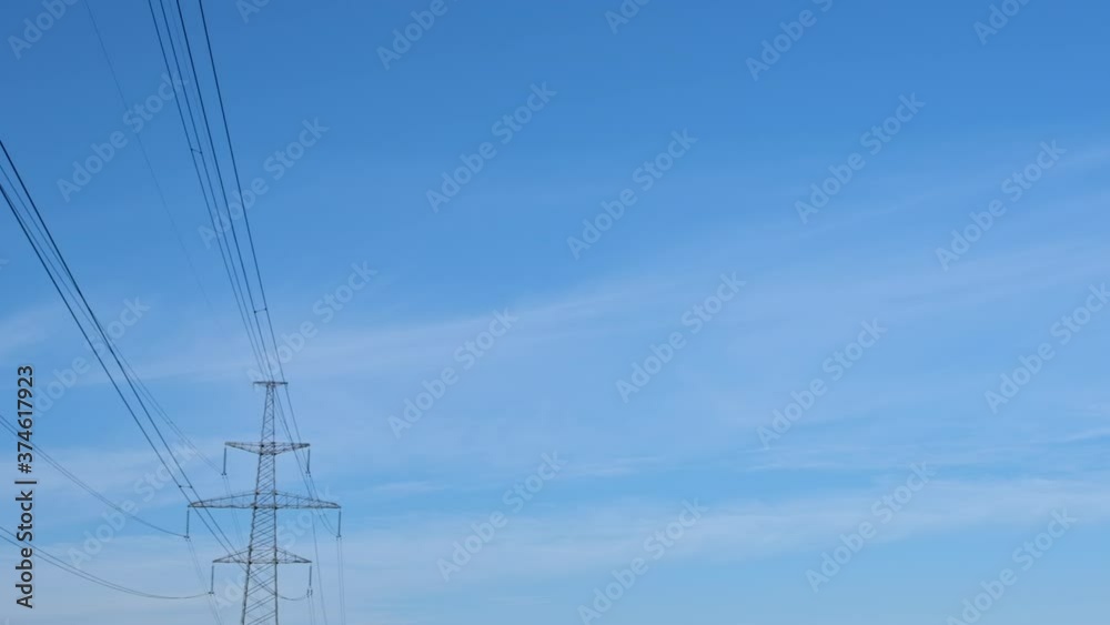 An white safety helmet flies into the air against a blue sky and high-voltage power line wires. An white safety helmet flies into the air against a blue sky and high-voltage power line wires.
